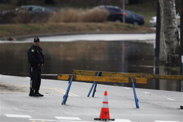 A police officer stands watch over a section of Kelly Drive flooded by waters from the Schuylkill River in Philadelphia, Friday, March 11.